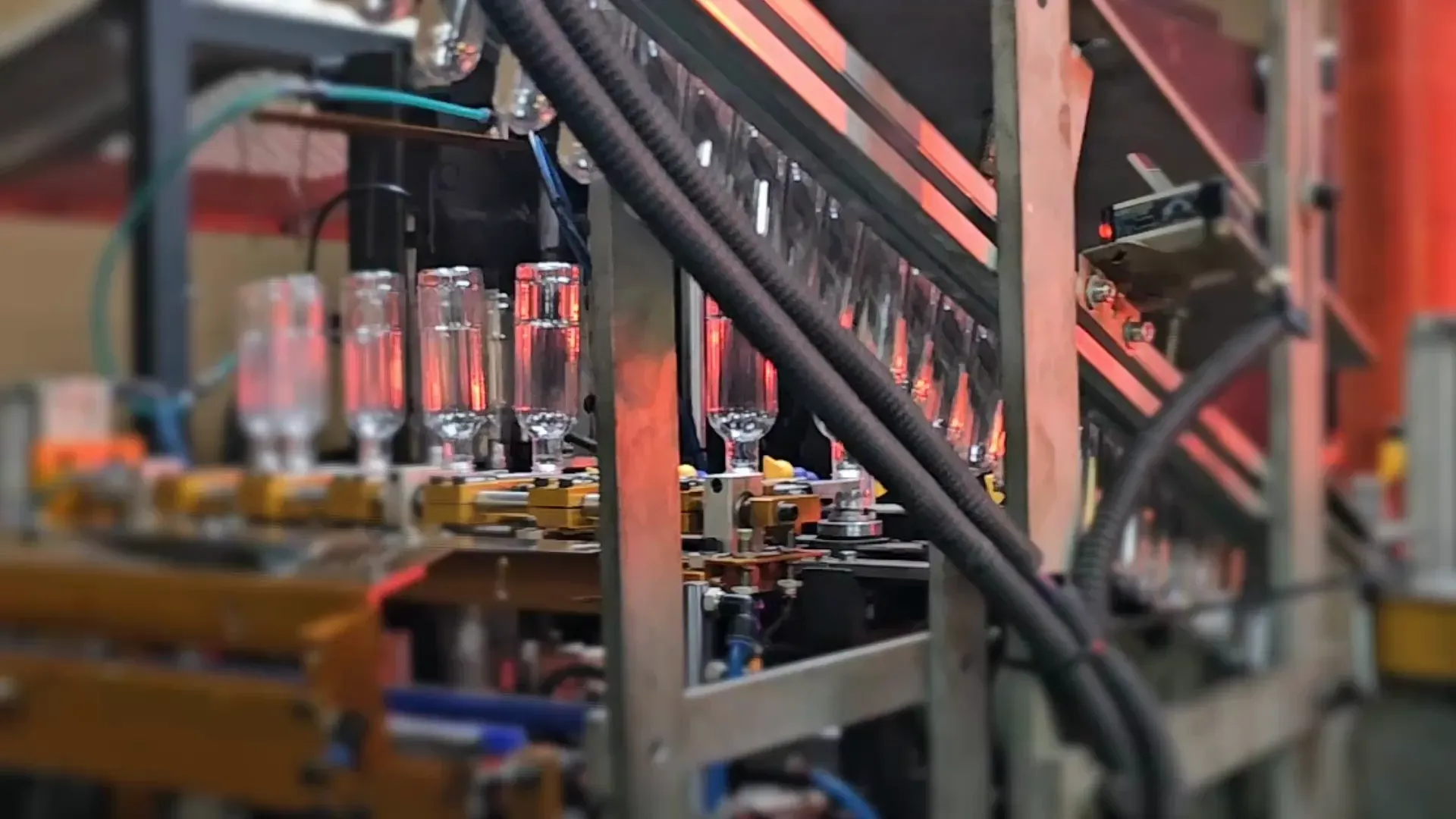 The blow-moulder forming PET bottles from preforms on the production line.